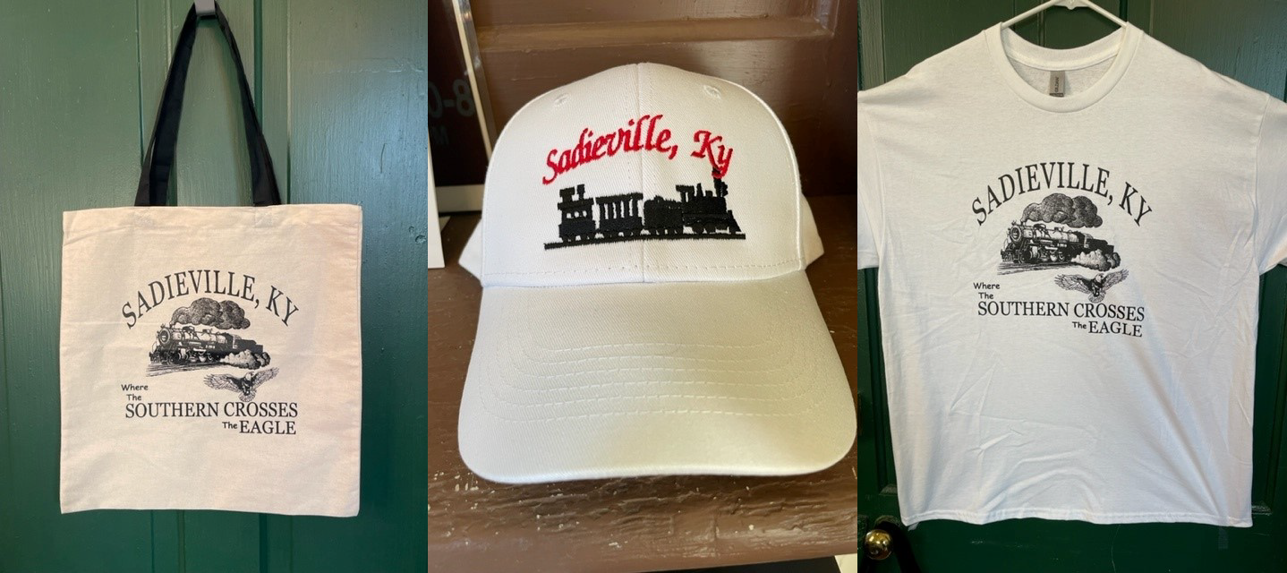 Tote bag, cap, and T-shirt featuring "Sadieville, KY" with train and eagle graphics.
